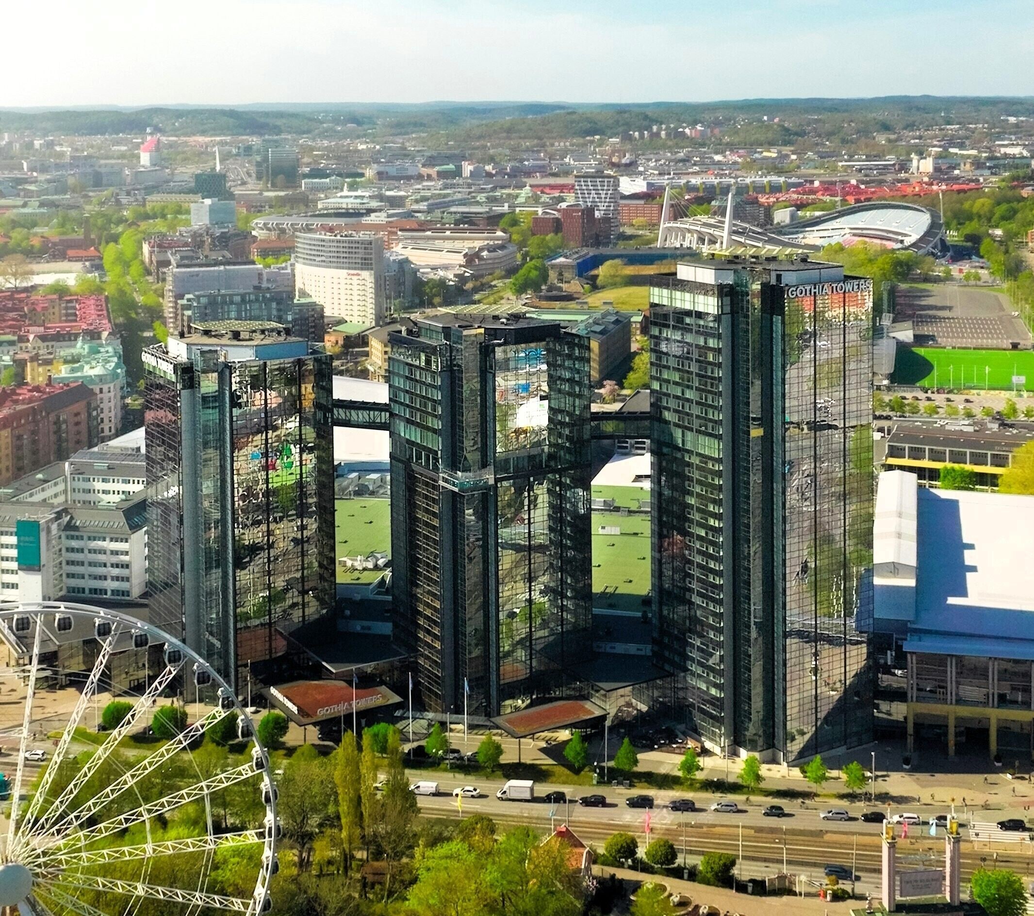 Un área urbana moderna con rascacielos, una noria y un estadio.