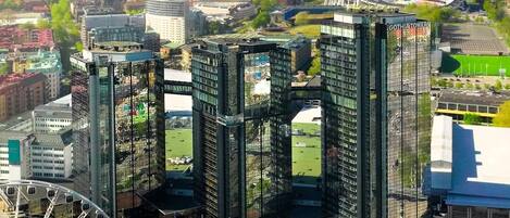 Un quartier urbain moderne avec de hauts immeubles, une grande roue et un stade.
