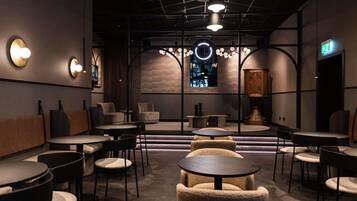 A modern interior with round tables, sofas, and a chandelier.