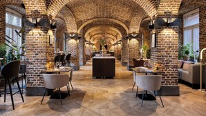 Ein Restaurant mit Ziegelgewölbe, Holzboden und moderner Einrichtung.