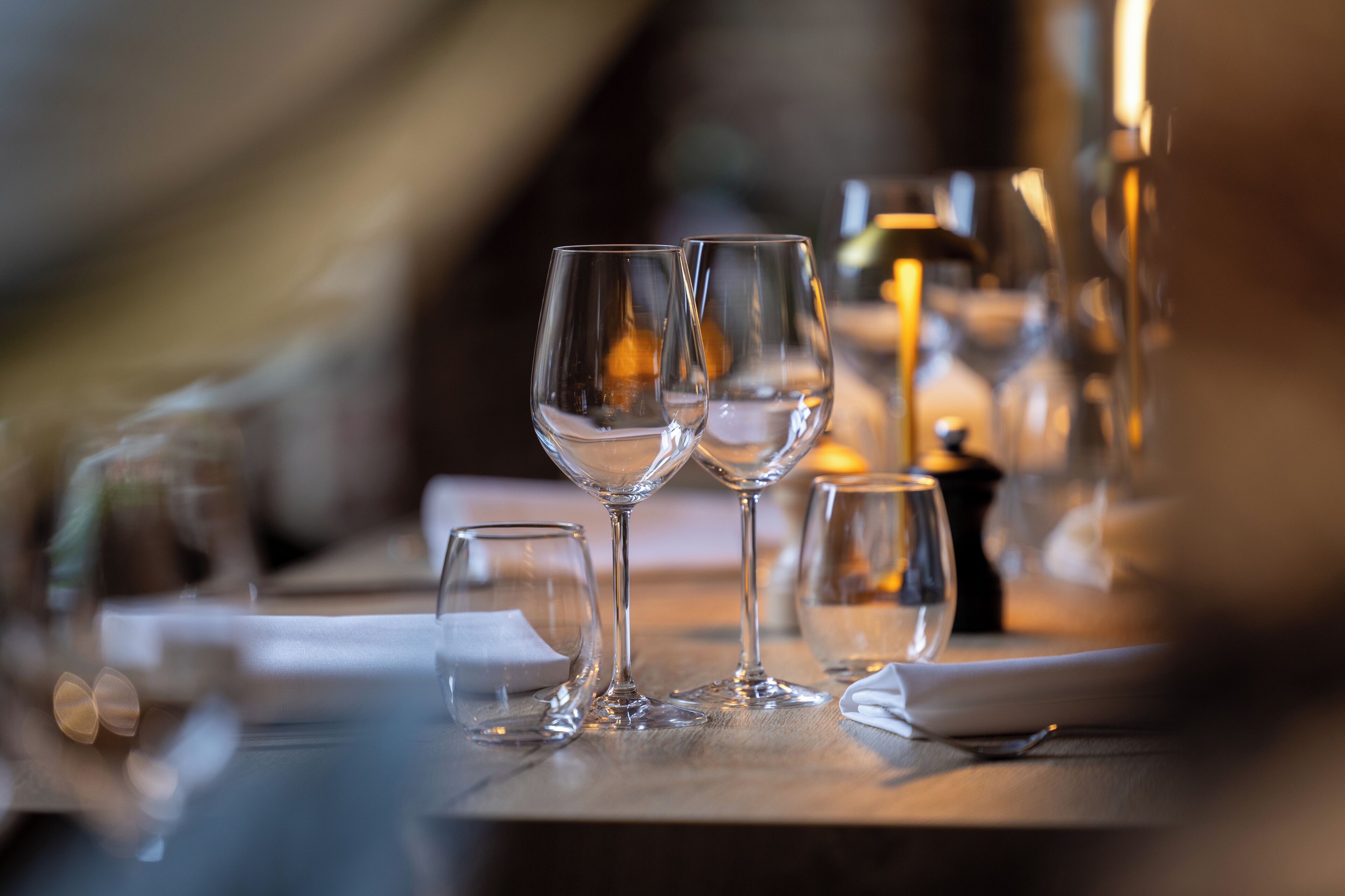Una mesa de comedor con varias copas de vino y una vela.