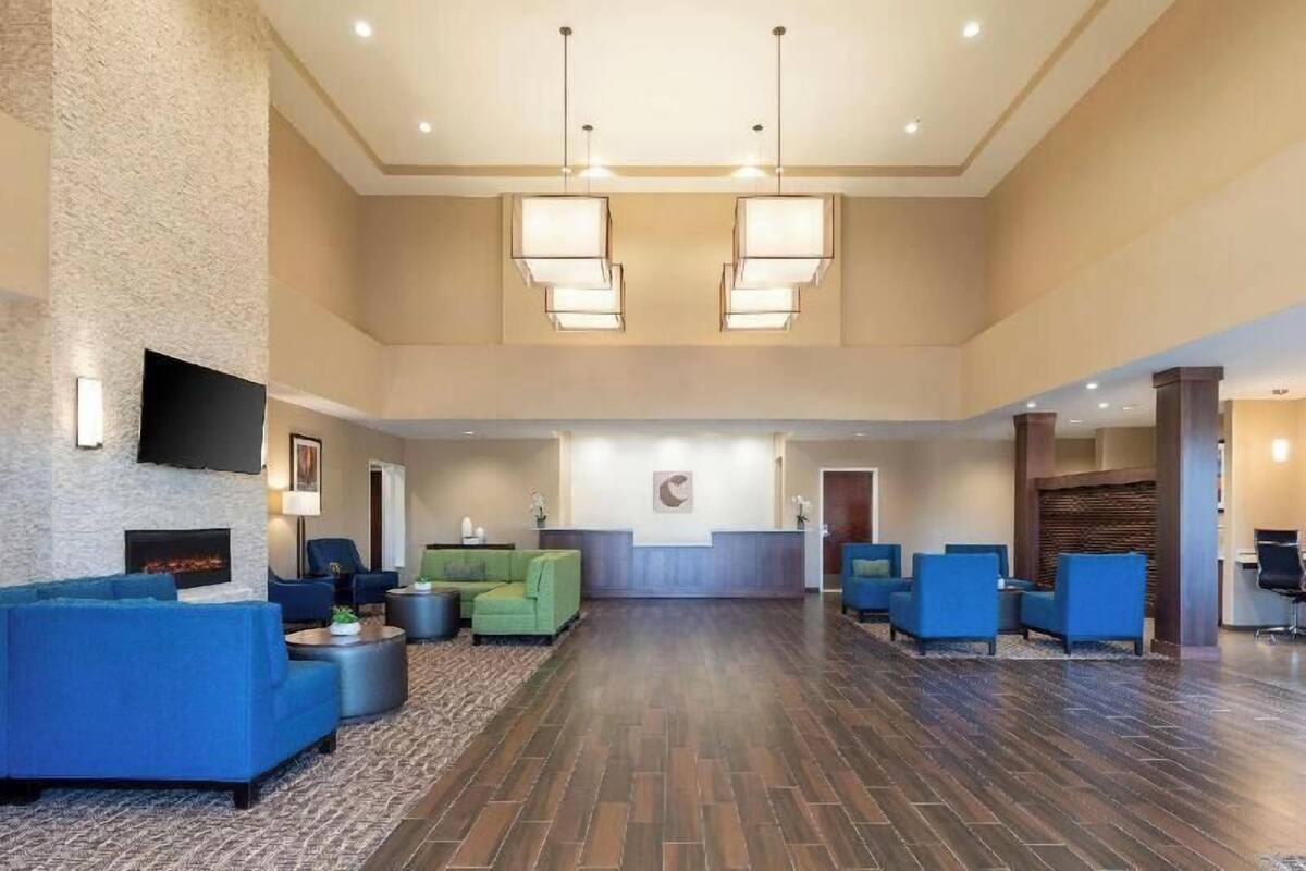A spacious lobby with a reception desk, seating area, and a fireplace.