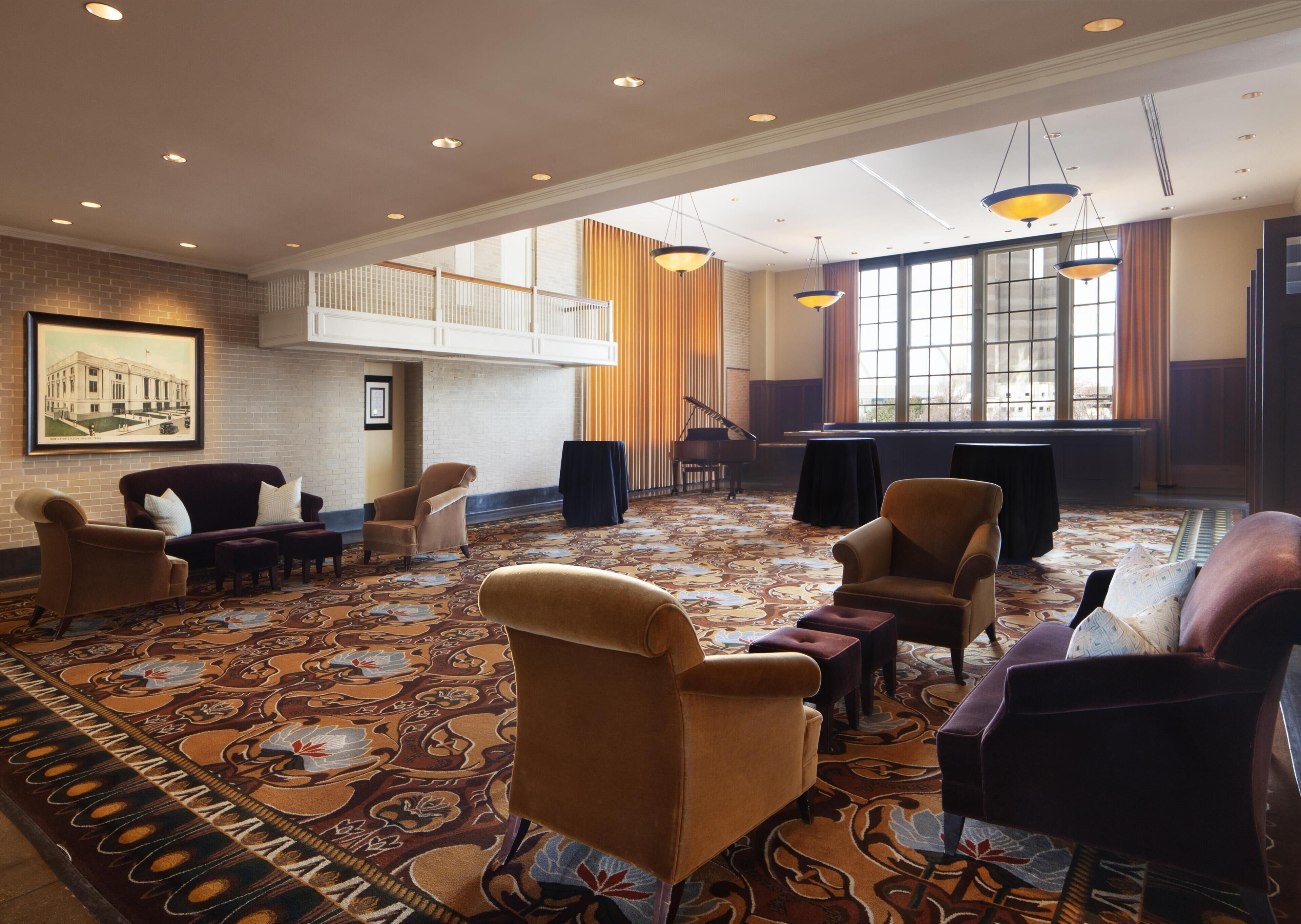 A spacious lobby with a high ceiling, a piano, and a grand piano.