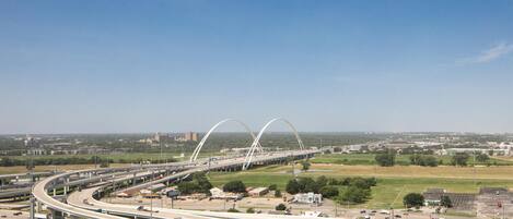 A multi-level highway interchange with overpasses and a large white bridge in the background.