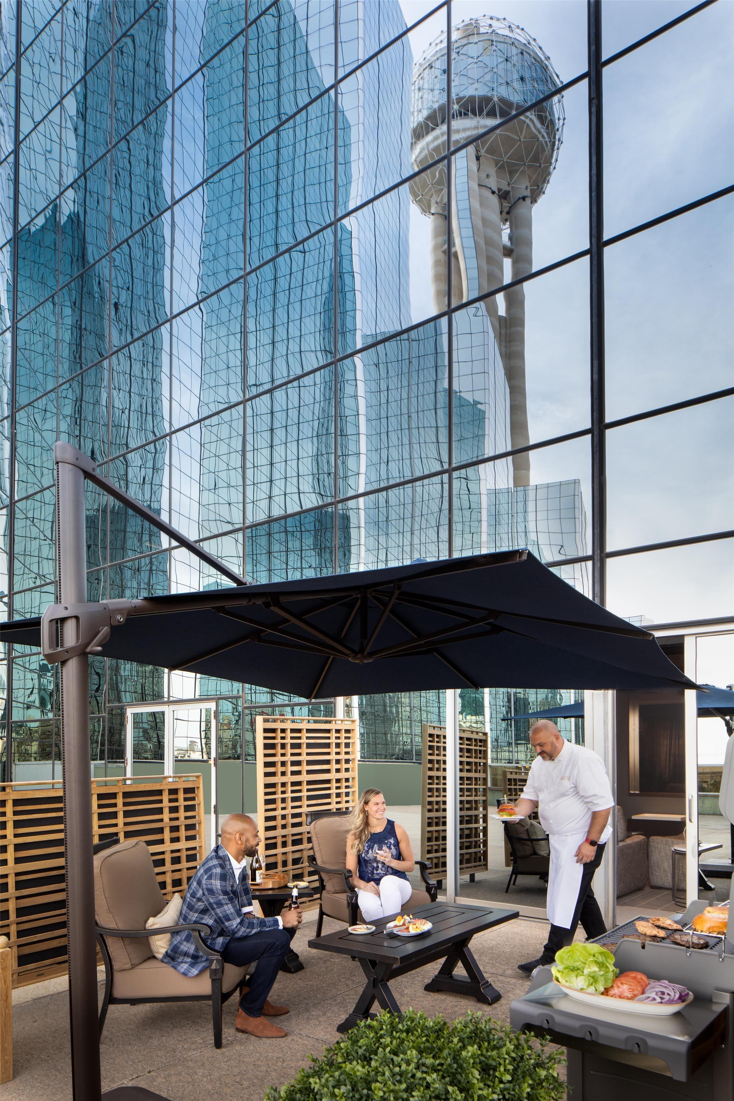 Een terras met uitzicht op een modern glazen gebouw.