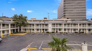 A multi-story motel with a parking lot in front. - Quality Inn & Suites Dallas - Cityplace (Dallas)