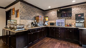 A hotel kitchen with a self-service breakfast station, a coffee machine, a microwave, and a refrigerator. - Quality Inn & Suites Dallas - Cityplace (Dallas)