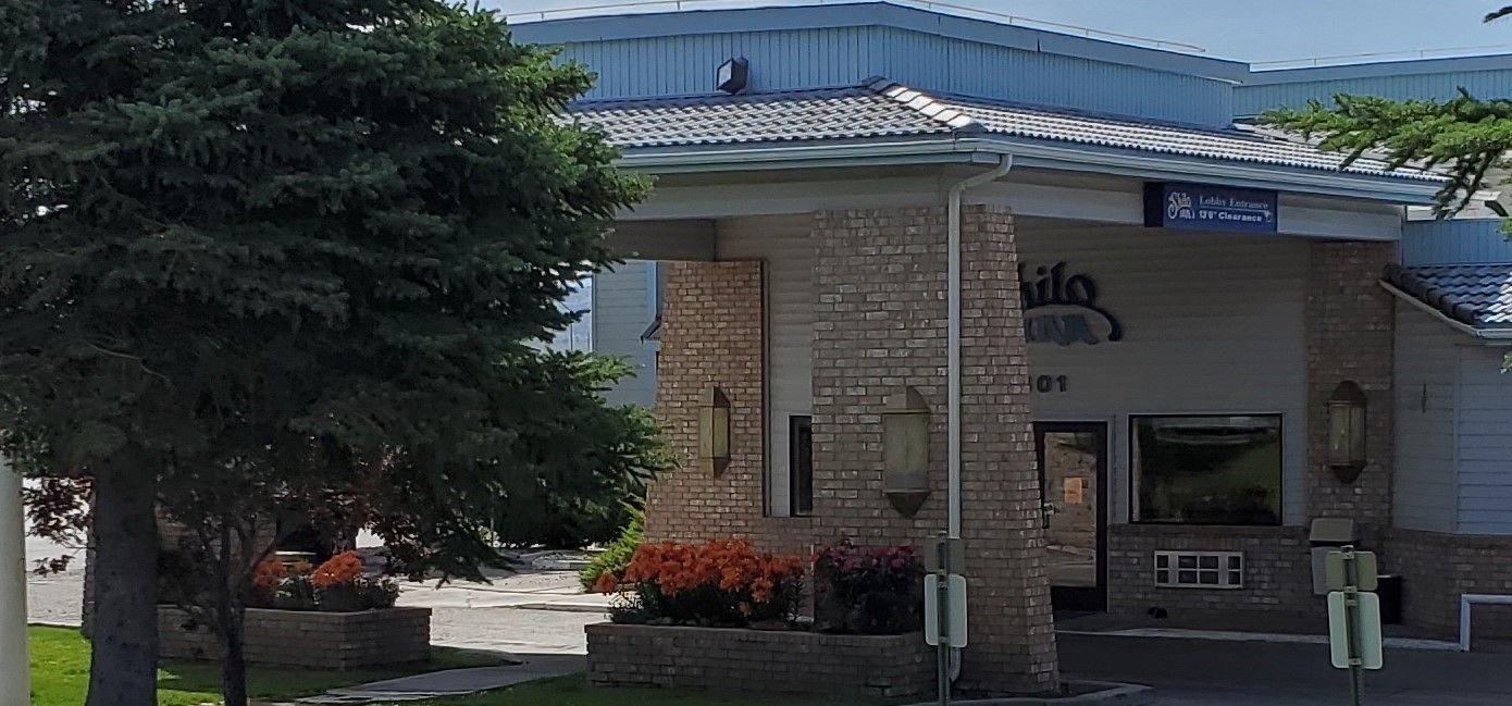 A building with a brick facade, a clear entrance, and a sign indicating a lobby entrance.