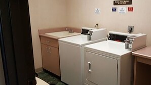 Una sala de lavandería con dos lavadoras y un lavabo.