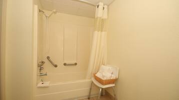 A bathroom with a bathtub, shower, and a wheelchair-accessible chair.