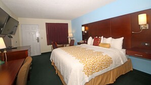 A hotel room with a large bed, a desk with a chair, a television, and a door. - Hamilton Inn Jonesville NC (Jonesville)