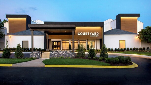 A modern Courtyard by Marriott hotel with a covered entrance, landscaped front yard, and a well-maintained driveway. - Courtyard by Marriott Silver Spring North/White Oak (Silver Spring)