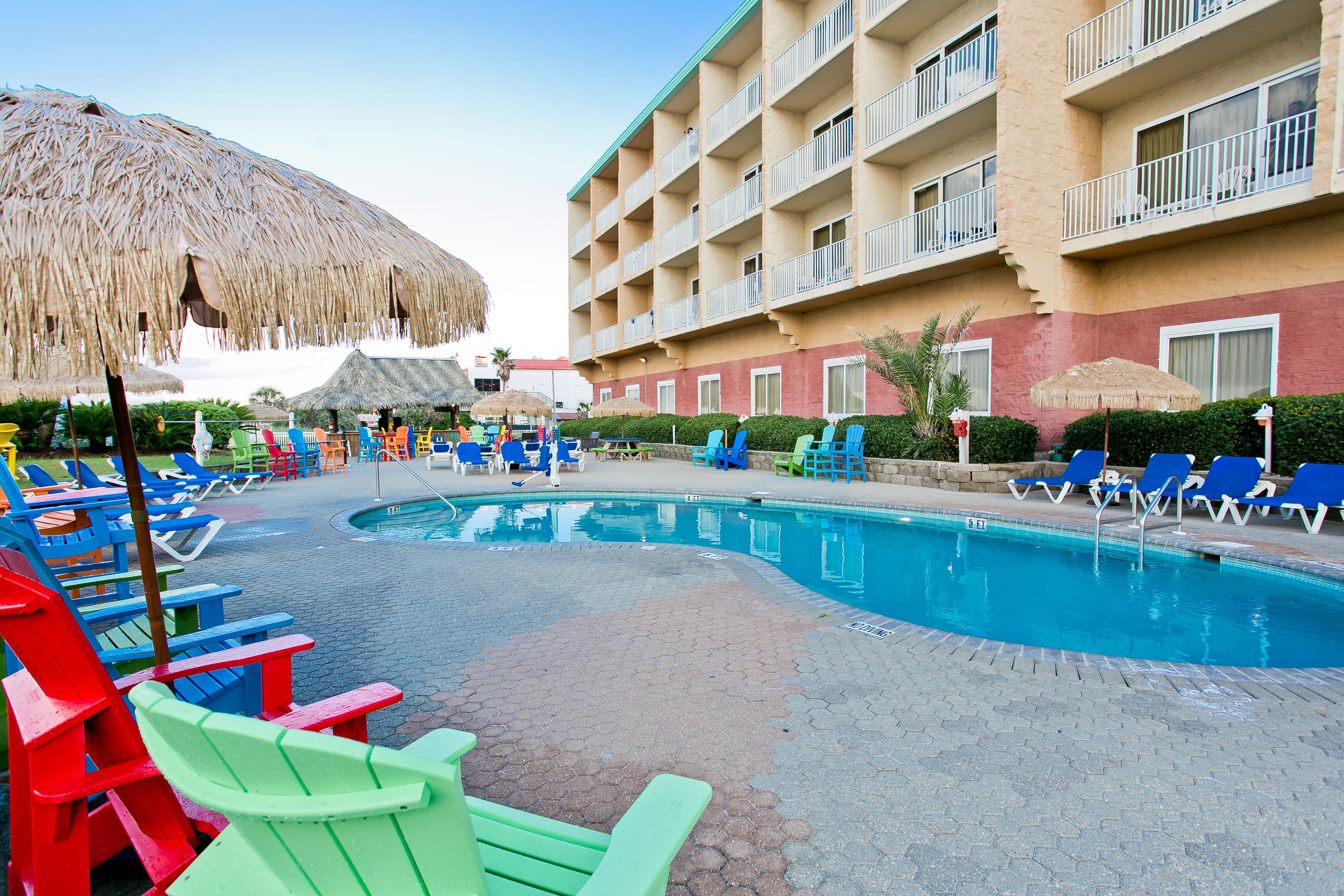 Un espace piscine d’hôtel avec des chaises longues et des parasols.