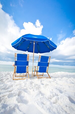 On the beach, white sand, sun-loungers, beach umbrellas