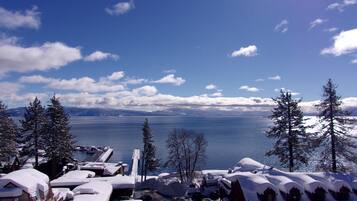 A lakeside view with snow-covered buildings and a dock extending into the water.