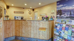 A reception desk with a wooden finish, a map on the wall, and a sign reading "Pepper Tree Inn". - Pepper Tree Inn (Tahoe City)