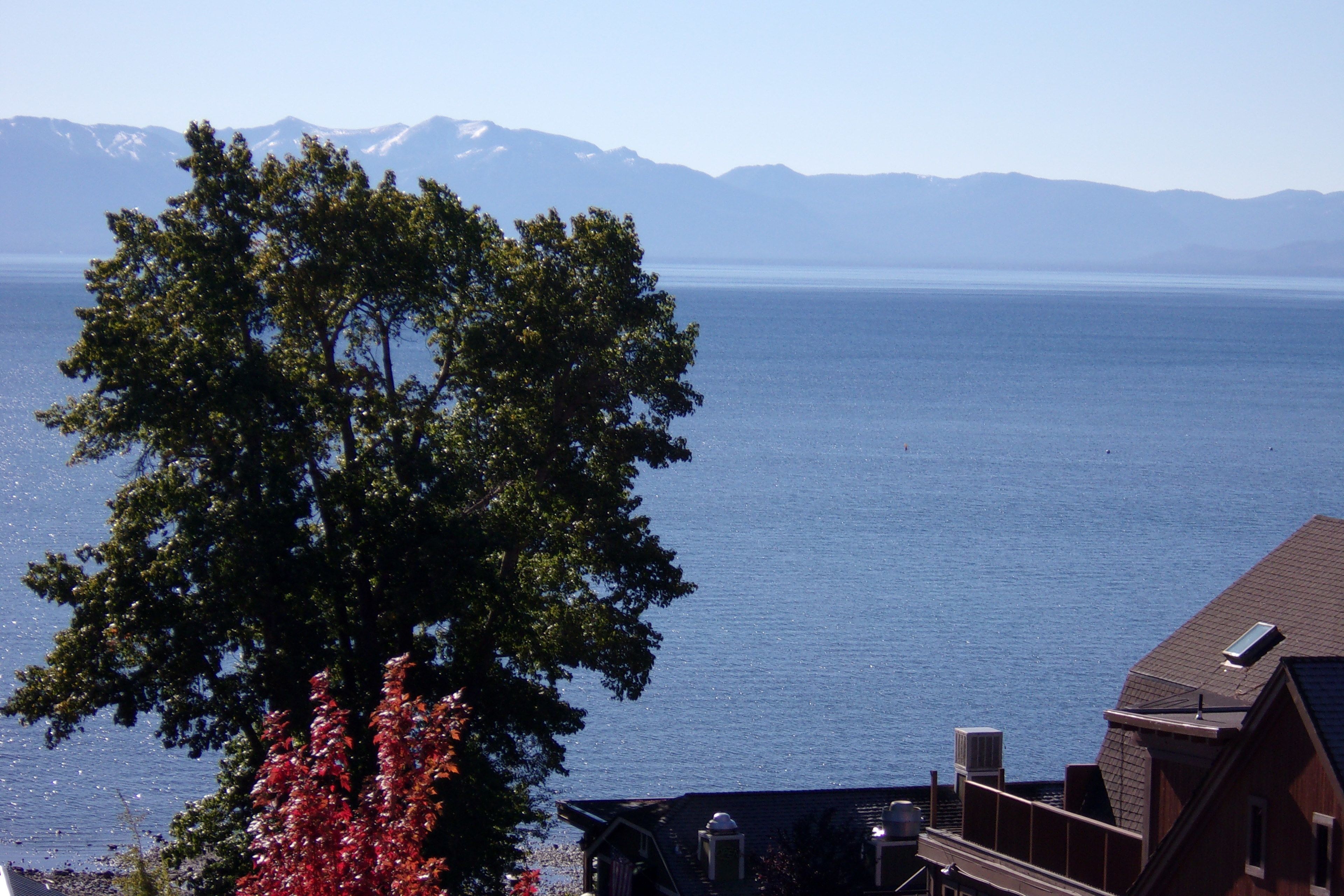 A house with a view of a lake and mountains in the background.