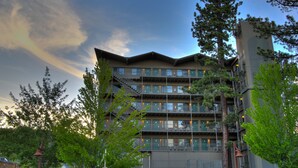A multi-story hotel with balconies, surrounded by trees and a clear sky. - Pepper Tree Inn (Tahoe City)