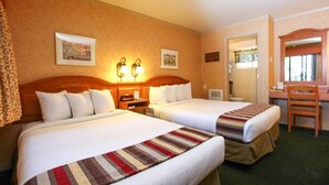 A hotel room with two beds, a desk, a chair, and a mirror. - Pepper Tree Inn (Tahoe City)