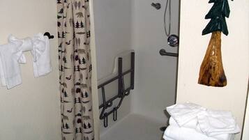 Un baño con ducha, toallero y una planta decorativa.