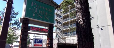 A sign for Pepper Tree Inn with a 'Welcome' message and an AAA Approved Lodging sign.