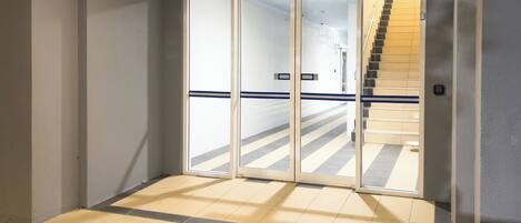 Un couloir avec une porte vitrée donnant sur un escalier.