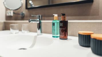 Un lavabo de salle de bain avec des articles de toilette, un miroir et un robinet.