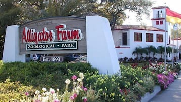 Placa para o Alligator Farm Zoological Park, com um edifício ao fundo.