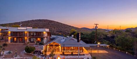 A hotel with a patio area, outdoor seating, and a fire pit.