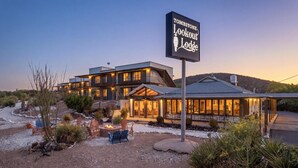 A multi-story lodge with a sign reading 'Tombstone Lookout Lodge,' outdoor seating, and a fire pit. - Tombstone Lookout Lodge, SureStay Collection by Best Western (Tombstone)
