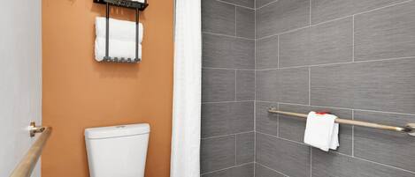 Un baño con inodoro, toallero y cortina de ducha.