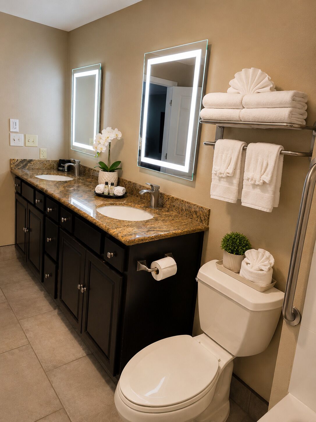 A bathroom with a sink, mirrors, a toilet, and towels.