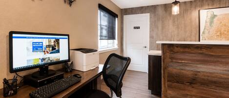 Un espace de bureau moderne équipé d’un ordinateur de bureau, d’une imprimante et d’un fauteuil de bureau.