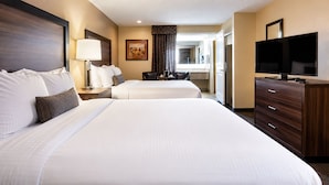 A hotel room with two beds, a TV, a dresser, and a painting on the wall. - Best Western John Day Inn (John Day)