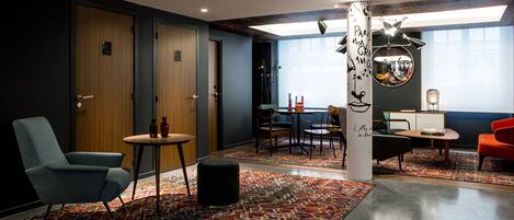 A modern interior with a seating area, a table with chairs, and a decorative pillar.