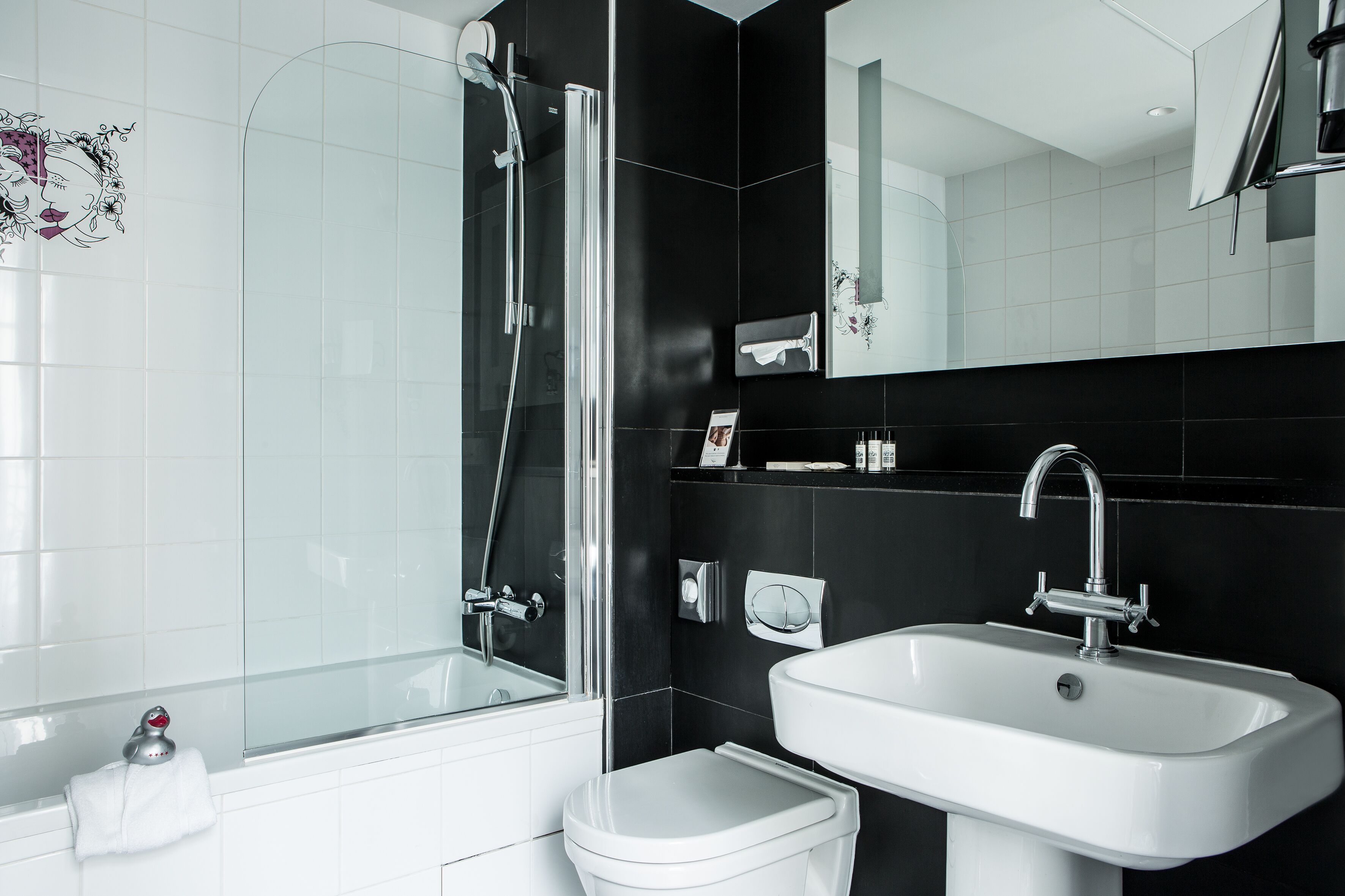 Une salle de bain moderne avec une douche à parois de verre, un lavabo blanc et des toilettes.