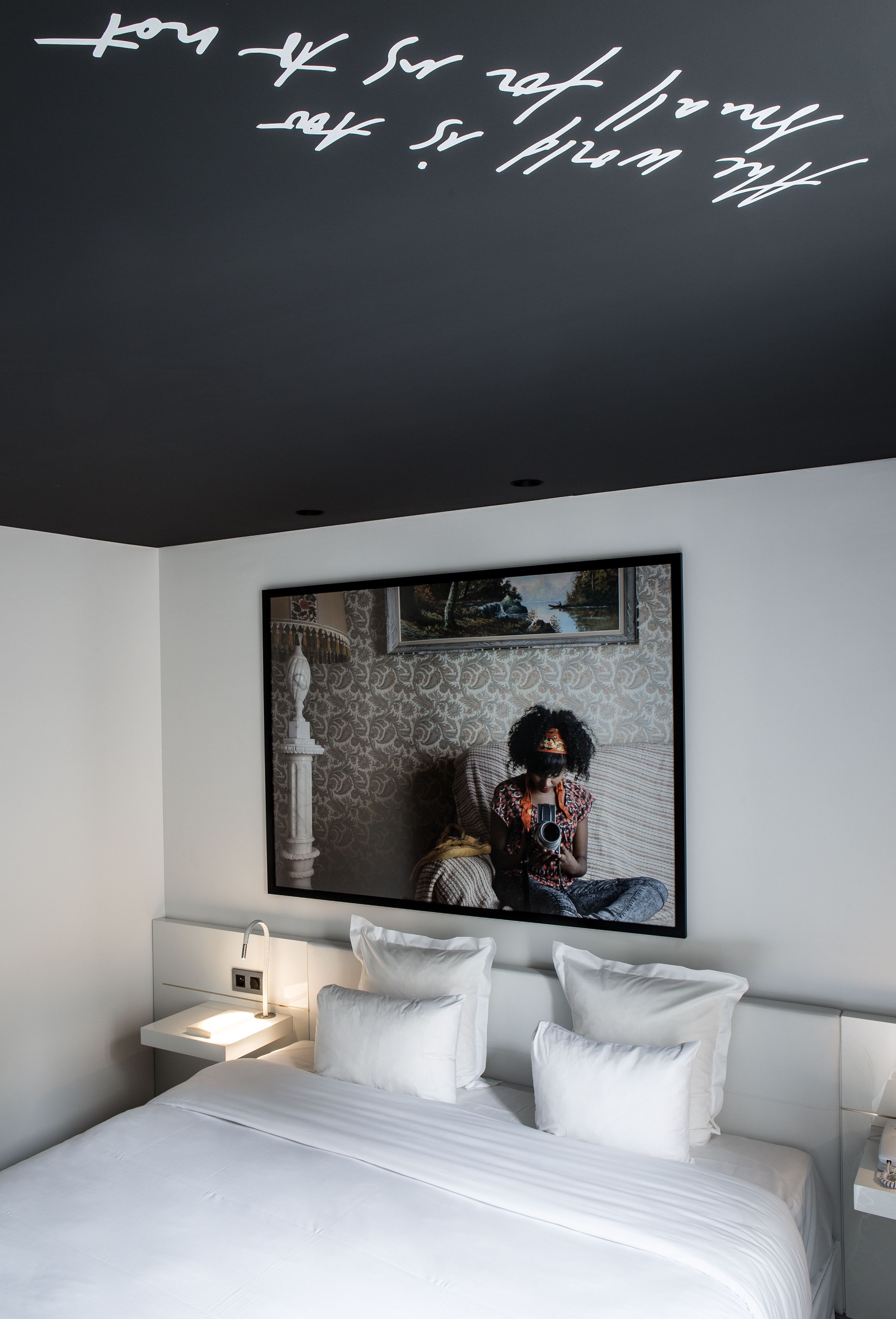 Un dormitorio moderno con una cama grande, una mesita de noche y un espejo en la pared.