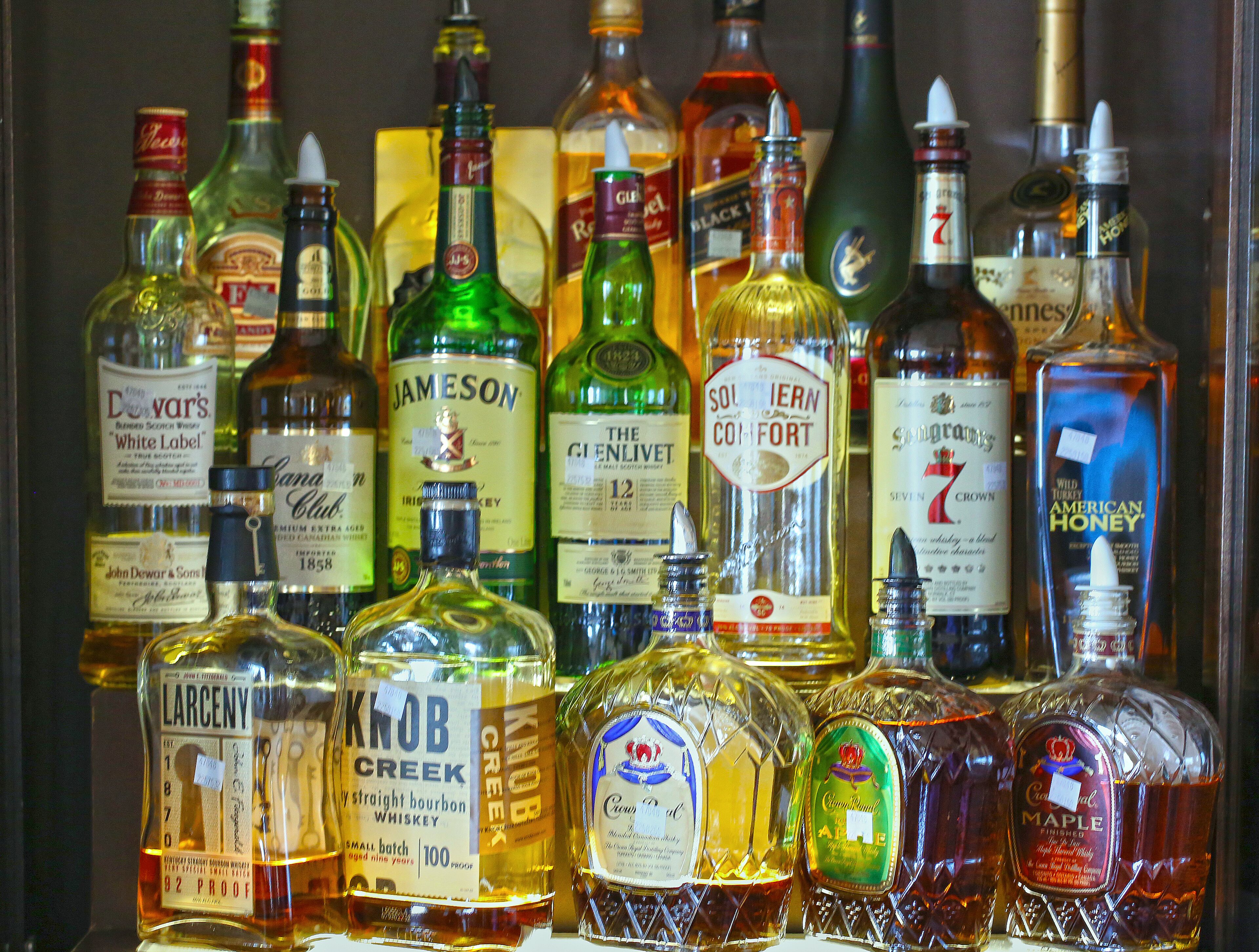 Eine Auswahl an Spirituosenflaschen mit Etiketten, darunter Marken wie Jameson und Glenlivet.