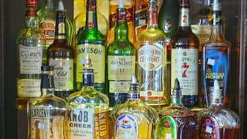En samling spritflaskor med etiketter, inklusive märken som Jameson och Glenlivet.