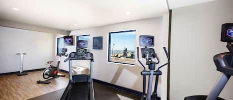 A fitness room with treadmills, a stationary bike, and a rowing machine.