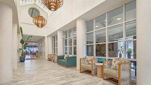 A spacious lobby with high ceilings, large windows, and modern furniture. - Hampton Inn Virginia Beach-Oceanfront North (Virginia Beach)