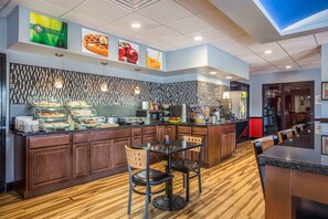 A breakfast bar with a wooden counter, a glass display case, and a seating area with two chairs.