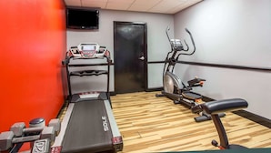 A gym with treadmills, dumbbells, and a stationary bike.
