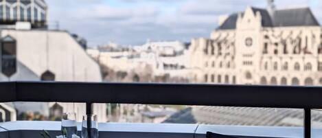 Una mesa dispuesta para dos con vistas a edificios históricos al fondo.