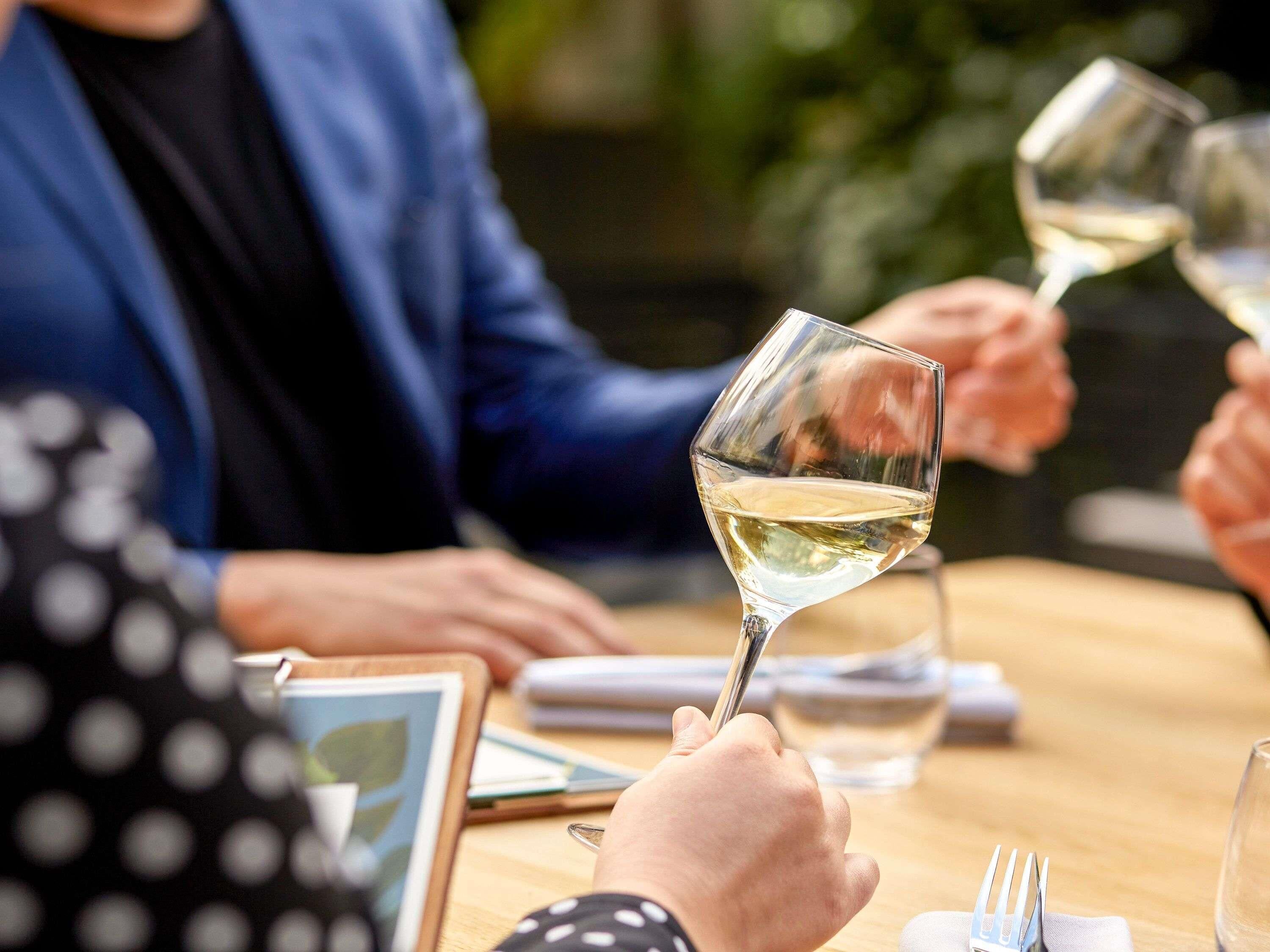 A group of people seated at a table with wine glasses, suggesting a social gathering or event.
