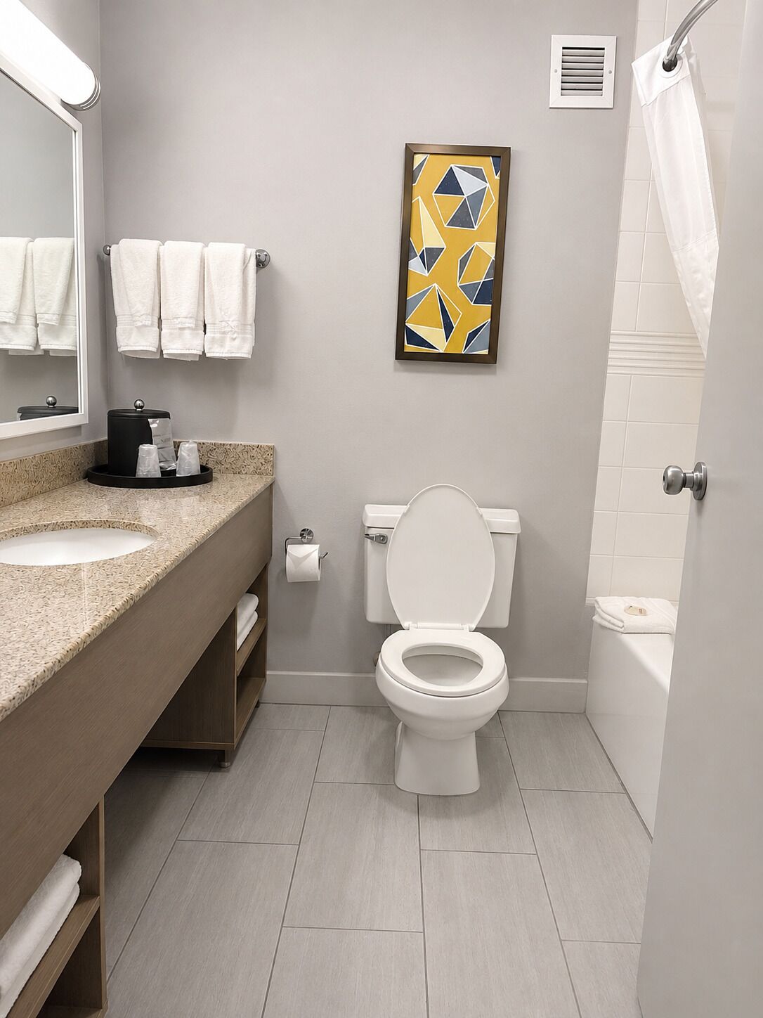 Un baño moderno con inodoro, lavabo y zona de ducha.