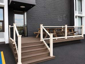 Eine Treppe führt zu einer Terrasse mit Sitzgelegenheiten.