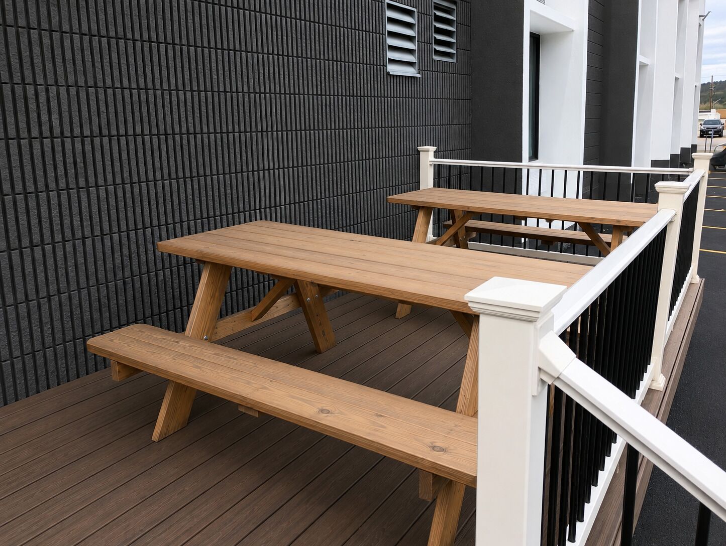 Un molo in legno con tavoli da picnic e una ringhiera.