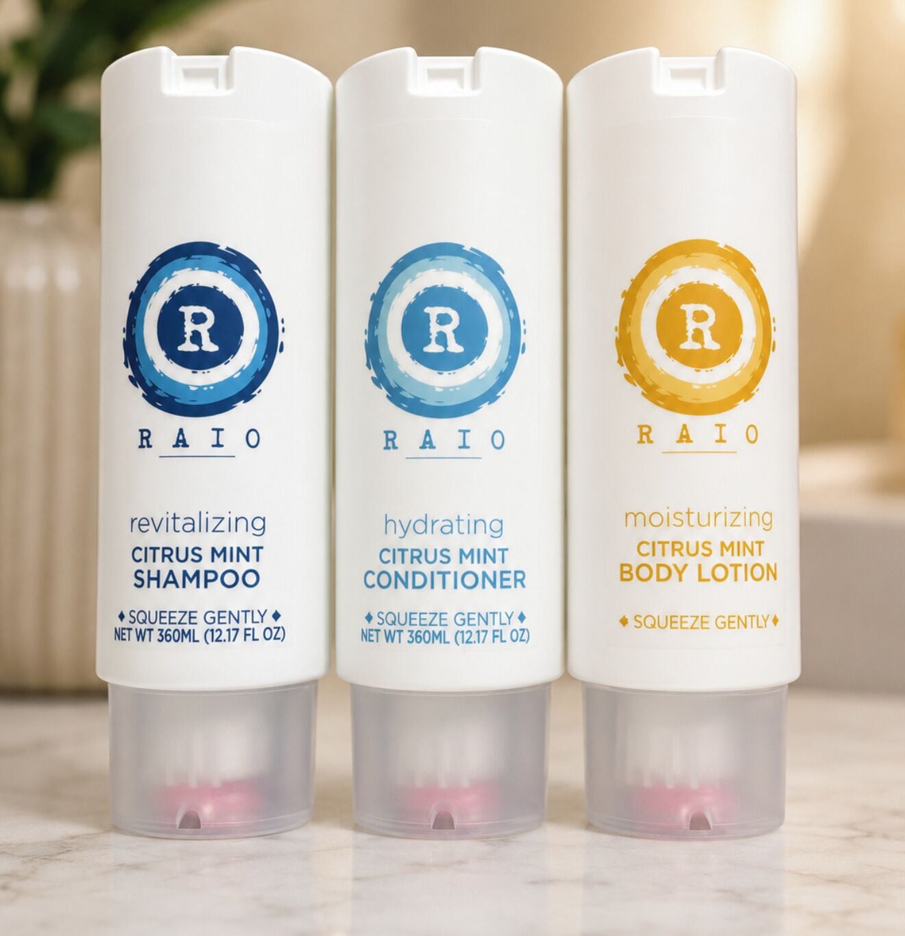 Three bottles of RAIO products: revitalizing citrus mint shampoo, hydrating citrus mint conditioner, and moisturizing citrus mint body lotion.