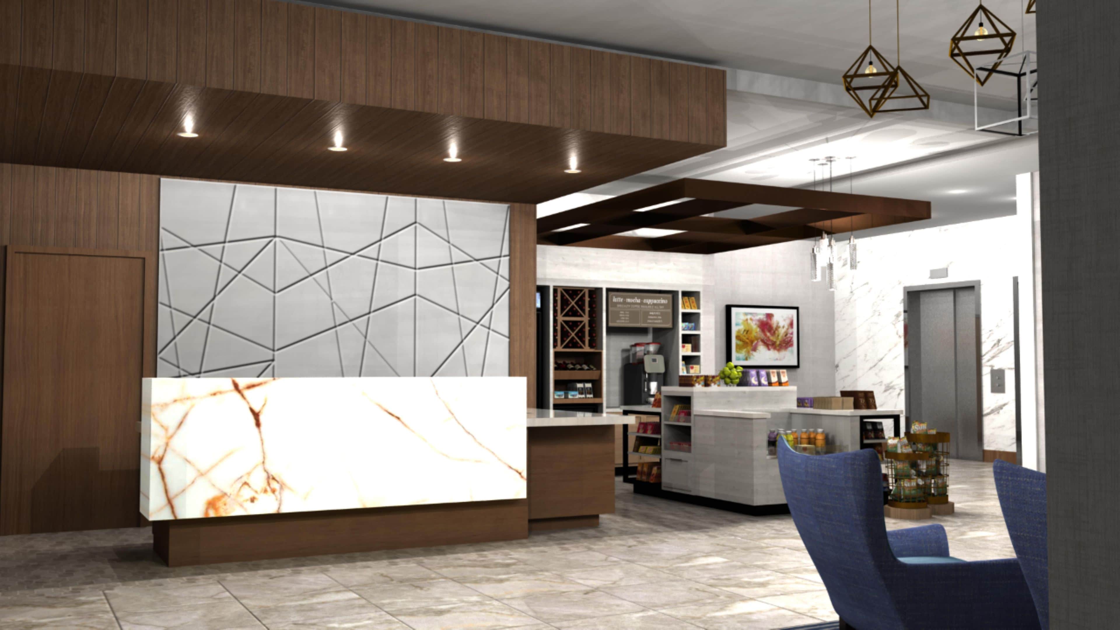 A modern interior with a reception desk, seating area, and a coffee station.